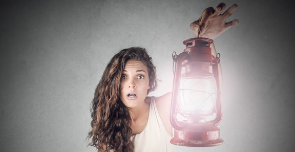 dark haired girl wearing a white dress and holding a lantern