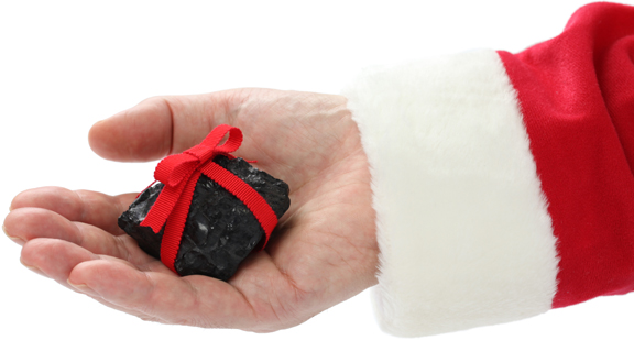 a coal with red ribbon on santa claus hand